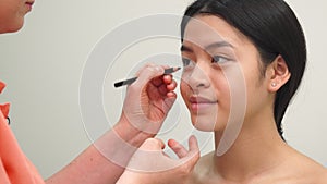 Beauty specialist uses cosmetic pencil