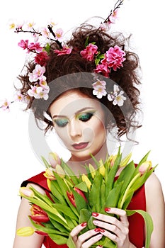 Beauty Spring Girl with Flowers Hair Style. Beautiful Model woman with Blooming flowers on her head. Nature Hairstyle. Summer. Ho