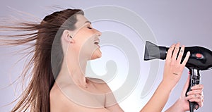 Beauty, straight hair and a woman blowing her hairstyle in studio on a gray background for grooming or style. Salon