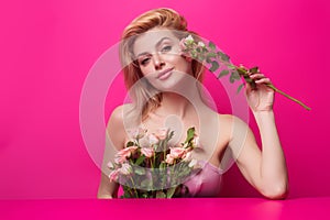 Beauty studio portrait. Beautiful model with pink rose flower, isolated on pink studio background. Charming young girl