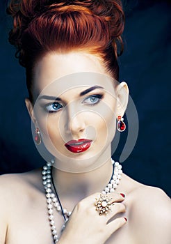 Beauty stylish redhead woman with hairstyle and manicure wearing jewelry pearl close up