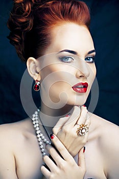 Beauty stylish redhead woman with hairstyle and manicure wearing jewelry pearl close up