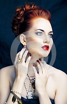 Beauty stylish redhead woman with hairstyle and manicure wearing jewelry pearl close up