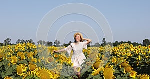 Beauty sunlit woman on yellow sunflower field Freedom and happiness concept. Happy girl outdoors/