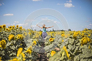 Beauty sunlit woman on yellow sunflower field Freedom and happiness concept. Happy girl outdoors