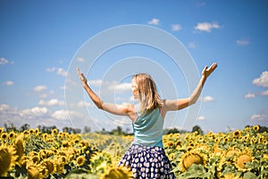 Beauty sunlit woman on yellow sunflower field Freedom and happiness concept. Happy girl outdoors