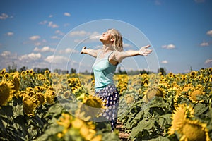 Beauty sunlit woman on yellow sunflower field Freedom and happiness concept. Happy girl outdoors