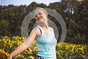 Beauty sunlit woman on yellow sunflower field Freedom and happiness concept. Happy girl outdoors