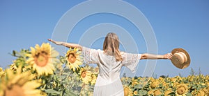 Beauty sunlit woman on yellow sunflower field Freedom and happiness concept. Happy girl outdoors