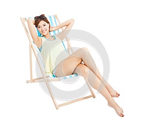 Beauty sunshine girl smiling and lying on a beach chair