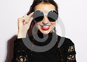 Beauty surprised fashion model girl wearing big sunglasses. Young girl. Makeup. Over white background.