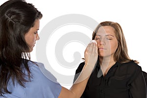 Beauty technician applying makeup on client