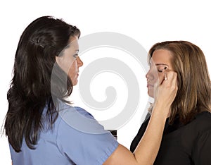 Beauty technician applying makeup on client