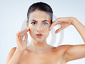 Beauty thatll leave you breathless. Studio portrait of an attractive young woman feeling her skin against a gray