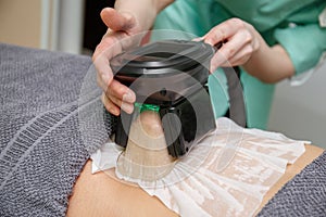 Beauty therapist applying cryolipolysis treatment. Non-surgical fat reduction