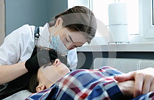 Beauty treatment. Beautician removes the black paint from the eyelashes with a cotton. laminating eyelashes.