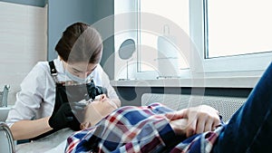 Beauty treatment. Beautician removes the black paint from the eyelashes with a cotton. laminating eyelashes.