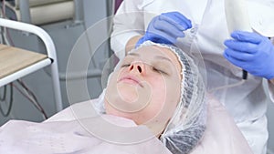 Beauty treatment facial electric darsonval therapy at cosmetology clinic.