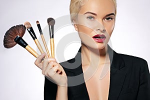 Beauty Treatment. Girl with Makeup Brushes. Fashion Make-up for Woman. Makeover. Make-up Artist Applying Visage