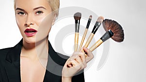 Beauty Treatment. Girl with Makeup Brushes. Fashion Make-up for Woman. Makeover. Make-up Artist Applying Visage