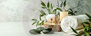 Beauty treatment items for spa procedures on white wooden table. massage stones, essential oils and sea salt. copy space