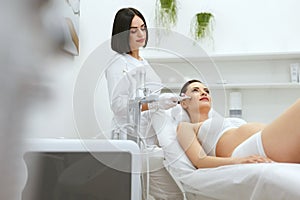 Beauty Treatment. Pregnant Woman Getting Therapy On Facial Skin
