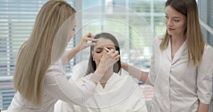 Beauty treatment results. Beautician draws contours on face of young patient