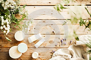 Beauty treatment and spa concept - close up of blank cosmetic bottles with lotion and cream on wooden table with copy space