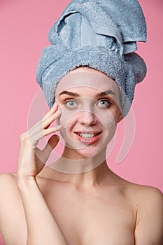 Beauty treatment - woman applying clay face mask