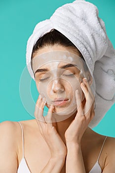 Beauty treatment - woman applying facial cleaning foam