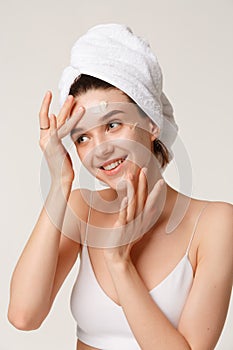 Beauty treatment - woman applying moisturing creame