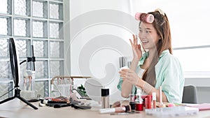 Beauty Vlogger concept, Young woman applying moisturizer cream on face to introduce product on Vlog