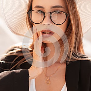 Beauty vogue portrait young gorgeous woman with pretty sexy lips in trendy glasses in vintage black jacket in elegant hat on