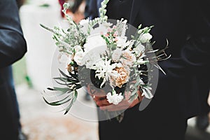 Beauty wedding bouquet with different flowers in hands