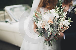 Beauty wedding bouquet with different flowers in hands