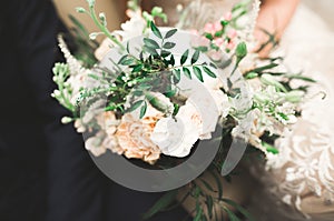 Beauty wedding bouquet with different flowers in hands