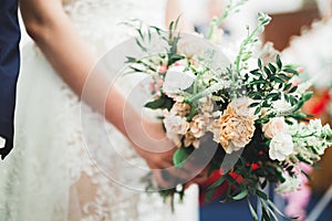 Beauty wedding bouquet with different flowers in hands