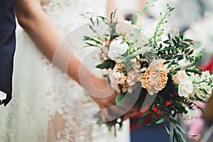 Beauty wedding bouquet with different flowers in hands