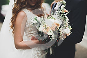 Beauty wedding bouquet with different flowers in hands