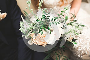 Beauty wedding bouquet with different flowers in hands