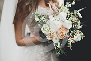 Beauty wedding bouquet with different flowers in hands