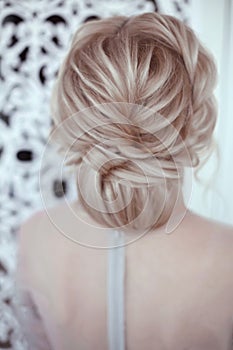Beauty wedding hairstyle. Bride. Blond girl with curly hair styling. Back view.