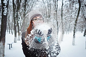 Beauty Winter Girl Blowing Snow in frosty winter Park