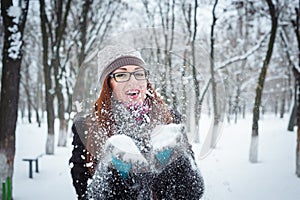 Beauty Winter Girl Blowing Snow in frosty winter Park