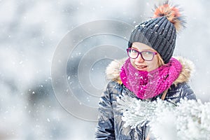 Beauty Winter Girl Blowing Snow in frosty winter park or outdoors. Girl and winter cold weather