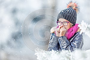 Beauty Winter Girl Blowing Snow in frosty winter park or outdoors. Girl and winter cold weather