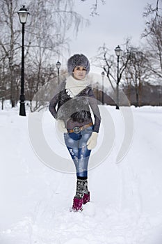 Beauty Winter Girl in frosty winter Park. Outdoors. Flying Snowflakes. Joyful Beauty young woman Having Fun in Winter Park.