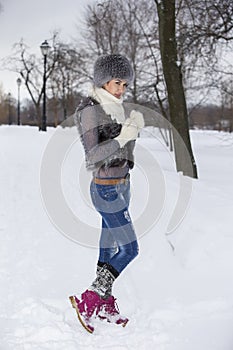 Beauty Winter Girl in frosty winter Park. Outdoors. Flying Snowflakes. Joyful Beauty young woman Having Fun in Winter Park.