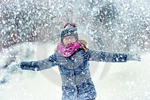 Beauty Winter happy Girl Blowing Snow in frosty winter park or outdoors. Girl and winter cold weather