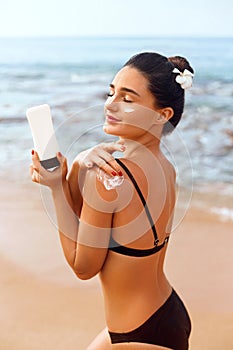 Beauty Woman apply Sun cream on tanned  back. Skin and Body Care.